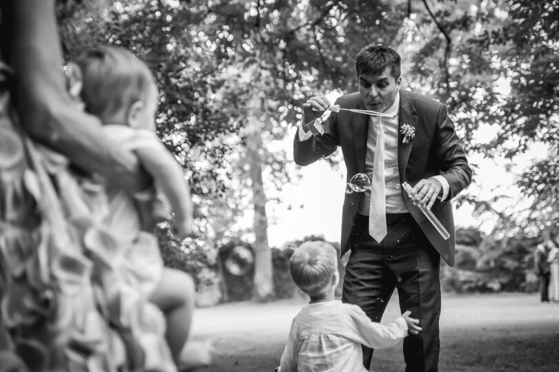 Papà dello sposo che gioca assieme al nipote con le bolle, Matrimonio a Carmagnola, Fotografo di Matrimoni a Torino