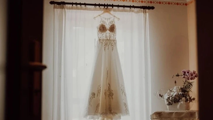 Abito da sposa appeso alla finestra, matrimonio a Cuneo, Fotografo di Matrimonio in Italia.