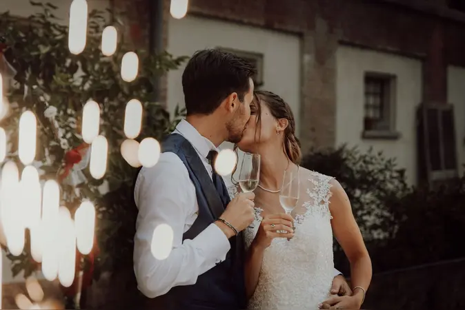 Coppia che si bacia durante il brindisi del taglio torta. Matrimonio a Bra, Fotografo di matrimonio a Cuneo.